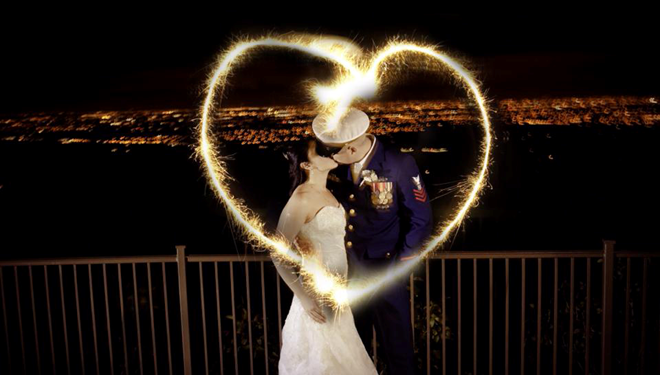 A newly married couple with sparklers making the shape of a heart.