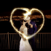 A newly married couple with sparklers making the shape of a heart.