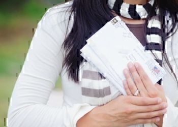 A women holding up letters to send to her husband.