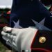 A folded national ensign is held carefully prior to the burial of Maj. Douglas A. Zembiec, former commander of E Company, 2nd Battalion, 1st Marine Regiment.  Zembiec was killed in action May 10.  He once told reporters during combat in Fallujah his Marines "fought like lions."  Zembiec was laid to rest by the Marine with whom he served May 15.