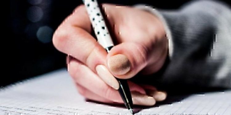 A women writing with a pen.