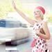 A women reaching out her hand to grab the attention of a taxi driver.