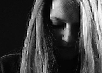 A women looking down with her hair covering her face.