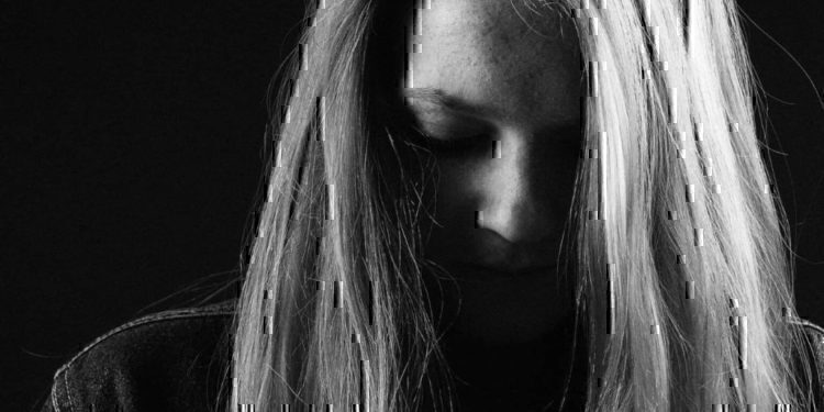 A women looking down with her hair covering her face.