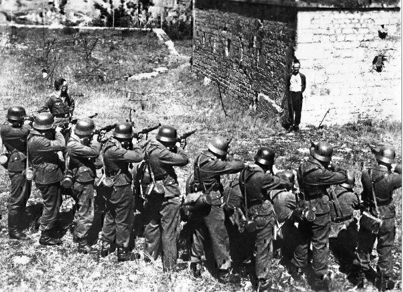 French Resistance member Georges Blind smiling in front of a German execution squad. October 1944. It was a mock execution intended to make him talk. (Photo: Nat'l Archives)