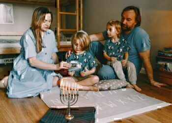 A family seated on the floor, celebrating hanukkah together.