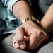 A couple holding hands while sitting on a couch.