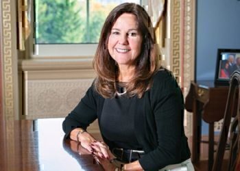 Karen Pence seated at a table, smiling for the camera.