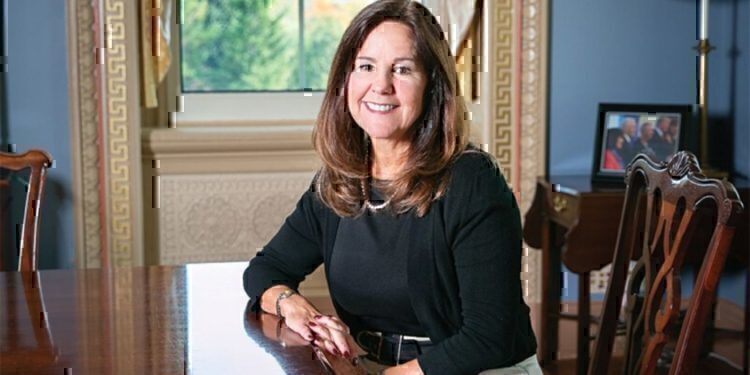 Karen Pence seated at a table, smiling for the camera.