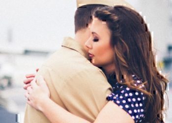 A wife hugging her husband before he leaves for his deployment.