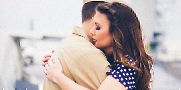 A wife hugging her husband before he leaves for his deployment.