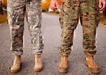 A dual military couple holding hands.