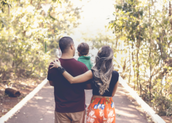 Parents holding their son, taking a walk in the woods and planning for the road ahead.