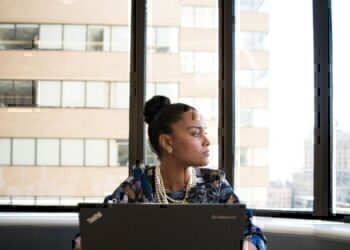 A working women briefly looking away from her computer and out of the window.