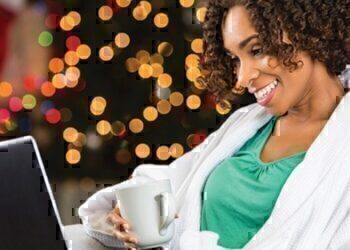 A mother looking at her computer as she shops for her family's Christmas gifts.