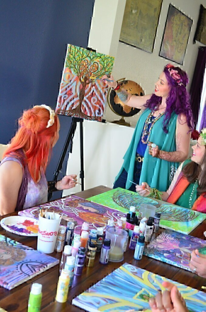 A groups of women using bright, beautiful colors to paint an amazing picture.