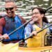 Two healthy couples who use Blue Cross Blue Shield for their vision insurance are paddling down the river in a kayak.