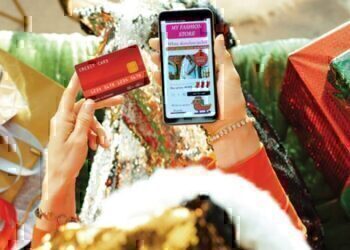 A women looking down at her phone as she makes an online purchase.