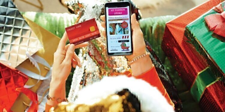 A women looking down at her phone as she makes an online purchase.