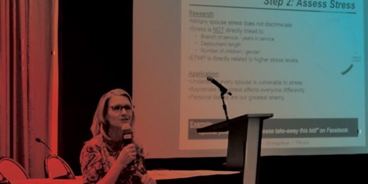 A women sitting down at a conference, talking about mental health.