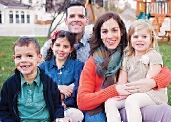 The Benscoter family sitting on green grass, smiling for the photograph.