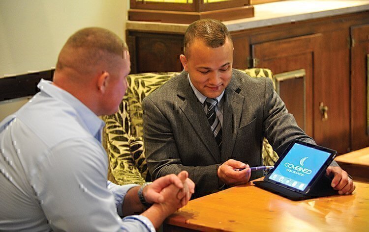 An insurance agent showing a customer the benefits of their service.