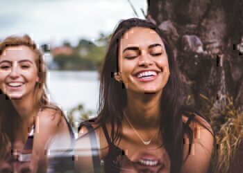 Two women sitting and smiling with each other.